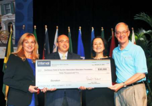 Neil Kolton, Director of Interval International (second from left), presents a donation to the Foundation at Caribbean Travel Marketplace earlier this year. At left is Nadine Rankin, Vice President of the Foundation; and at right is Karolin Troubetzkoy, CHTA President and Ernest Dwight, Chair of the Foundation's Auction Committee.