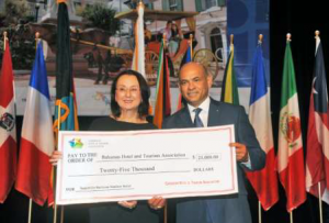 The Bahamas Hotel & Tourism Association's (BHTA) President Carlton Russell receives CHTA's contribution from President Karolin Troubetzkoy. 